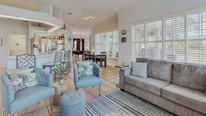 A spacious living area with a sofa, armchairs, and a dining table. - Canal-Front Home with Private Pool and Dock, WiFi, and Pool Table (Cape Coral)