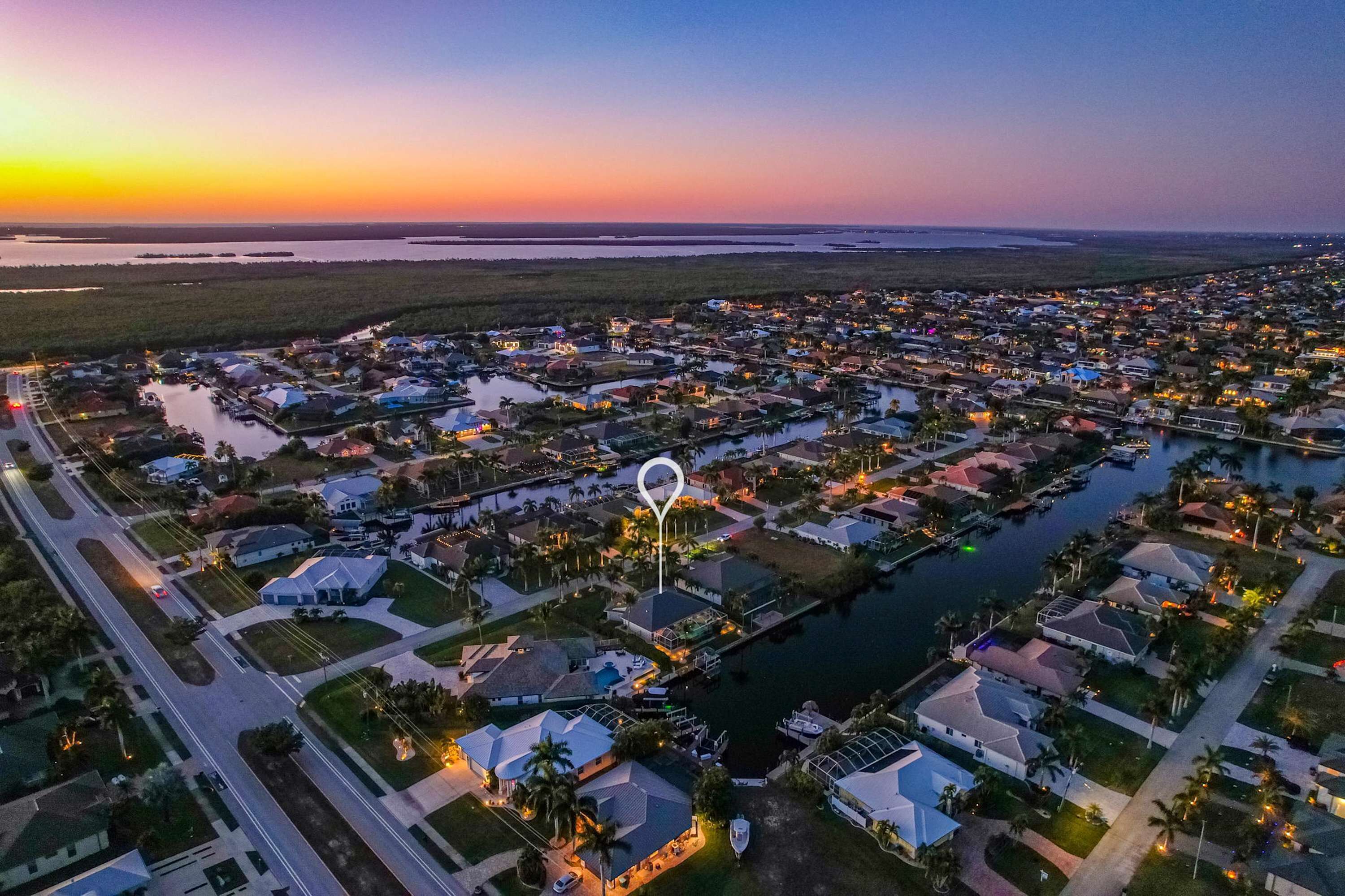 An aerial view of a residential area with houses, a marina, and a body of water.