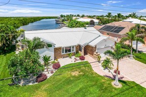 A residential property with a large house, a river view, and a well-maintained garden. - Exquisite waterfront home with private pool, hot tub, amd dock (Cape Coral)