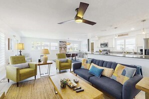 A modern living room with a sofa, chairs, a coffee table, and a ceiling fan. - Relaxing retreat with private pool, washer/dryer, & family-friendly amenities (Cape Coral)