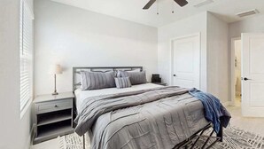 A bedroom with a bed, nightstand, and ceiling fan. - Coastal duplex with internet, washer and dryer, and dog friendly (Englewood)