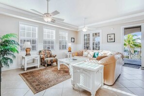 A living room with a sofa, armchairs, a coffee table, and a fireplace. - Family-Friendly, Gulf View Condo w/ Pool - Walk to the Beach (Fort Myers Beach)