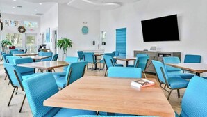Moderni hotellihuone, jossa on suuri sänky, taulutelevisio, työpöytä ja tuoli.