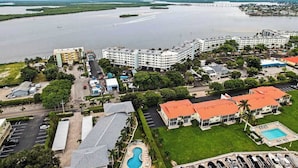 A coastal hotel with multiple buildings, a swimming pool, and a marina. - Waterview condo with shared pool, panoramic balcony views, and WIFI (Marco Island)