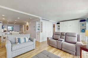 A living room with a grey sofa, a beige sofa, and a dining area with a table and chairs. - Waterview condo with shared pool, panoramic balcony views, and WIFI (Marco Island)