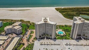 Een kusthotel met meerdere hoge gebouwen, een strand en een zwembad.