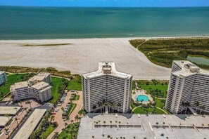 A coastal hotel with multiple high-rise buildings, a beach, and a swimming pool. - Gulf-front getaway with on-site pool, tennis, putting green, dock, & gym (Marco Island)