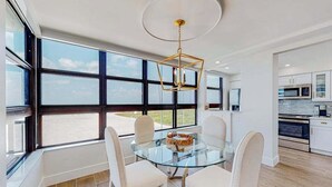 Een moderne keuken met witte kasten, een magnetron en een fornuis.