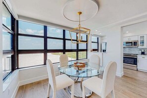 A modern kitchen with white cabinets, a microwave, and a stove. - Gulf-front getaway with on-site pool, tennis, putting green, dock, & gym (Marco Island)