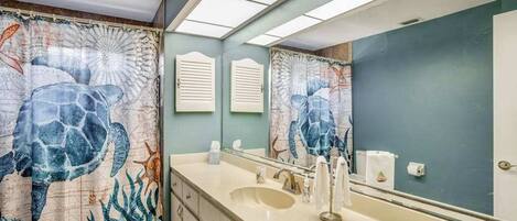 A bathroom with a large mirror, a sink, and a toilet.
