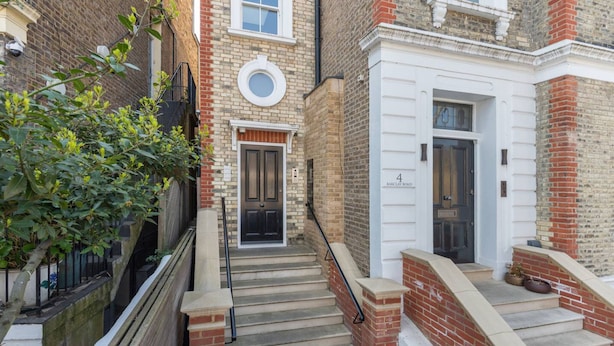 A narrow alleyway with a brick building, a black door, and a white door with a number plaque. - New 1 Bed Flat Near Central London With Terrace (London)