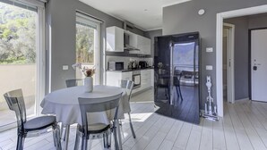 A modern kitchen with a built-in microwave, oven, and refrigerator. - Open View Apartment by Wonderful Italy (Oliveto Lario)