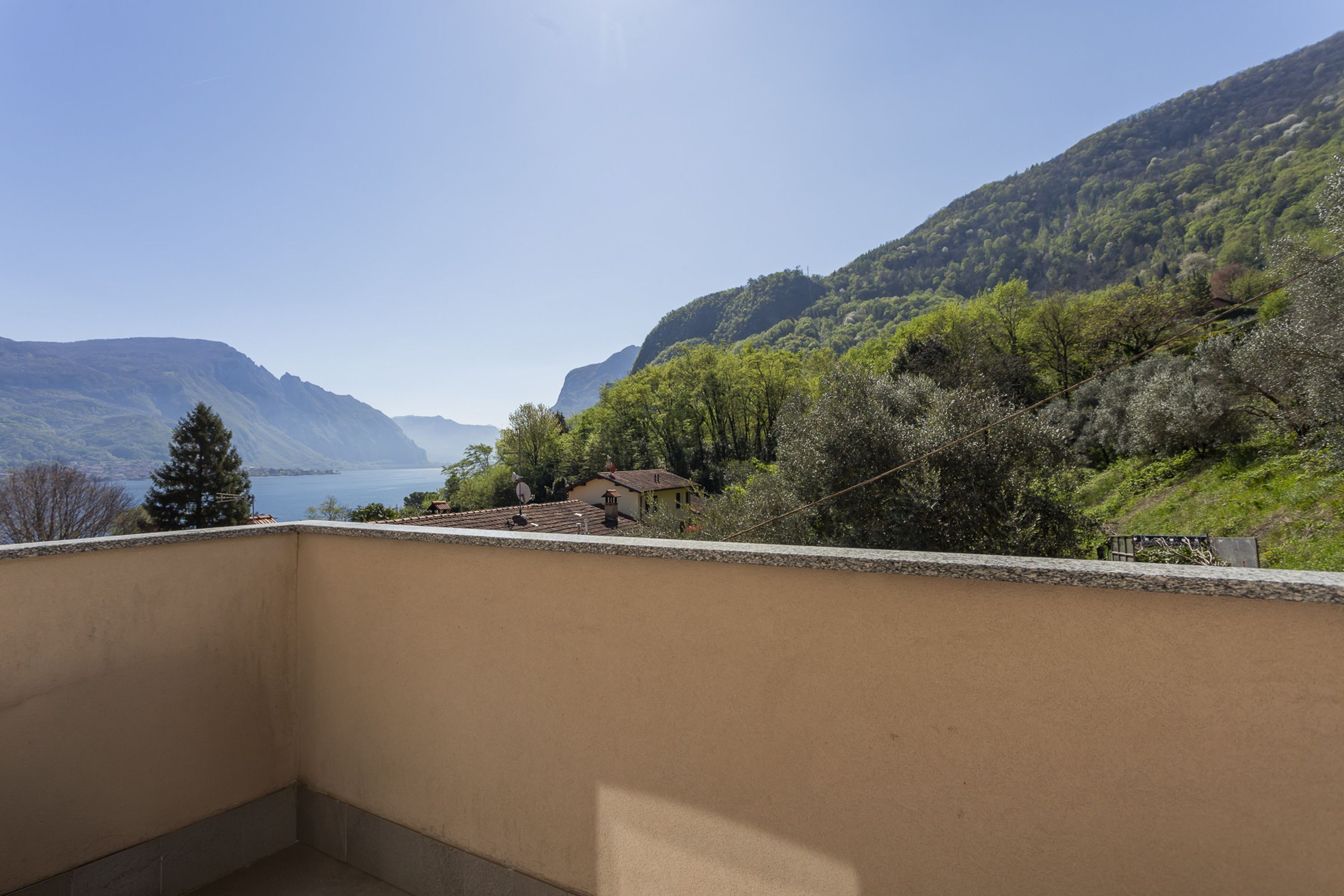 A balcony with a view of a lake and mountains.