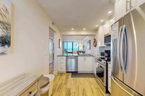A modern kitchen with stainless steel appliances, white cabinetry, and a wooden floor. - Gulf-Front Condo on Tigertail Beach w/ Sunset Views, Balcony, Shared Pool/Tennis (Marco Island)