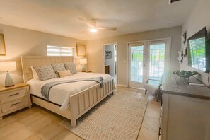 A bedroom with a bed, nightstands, a desk, and a ceiling fan. - Pet Friendly home, private pool w/ heat included, enclosed yard, fire pit, bikes (Naples)