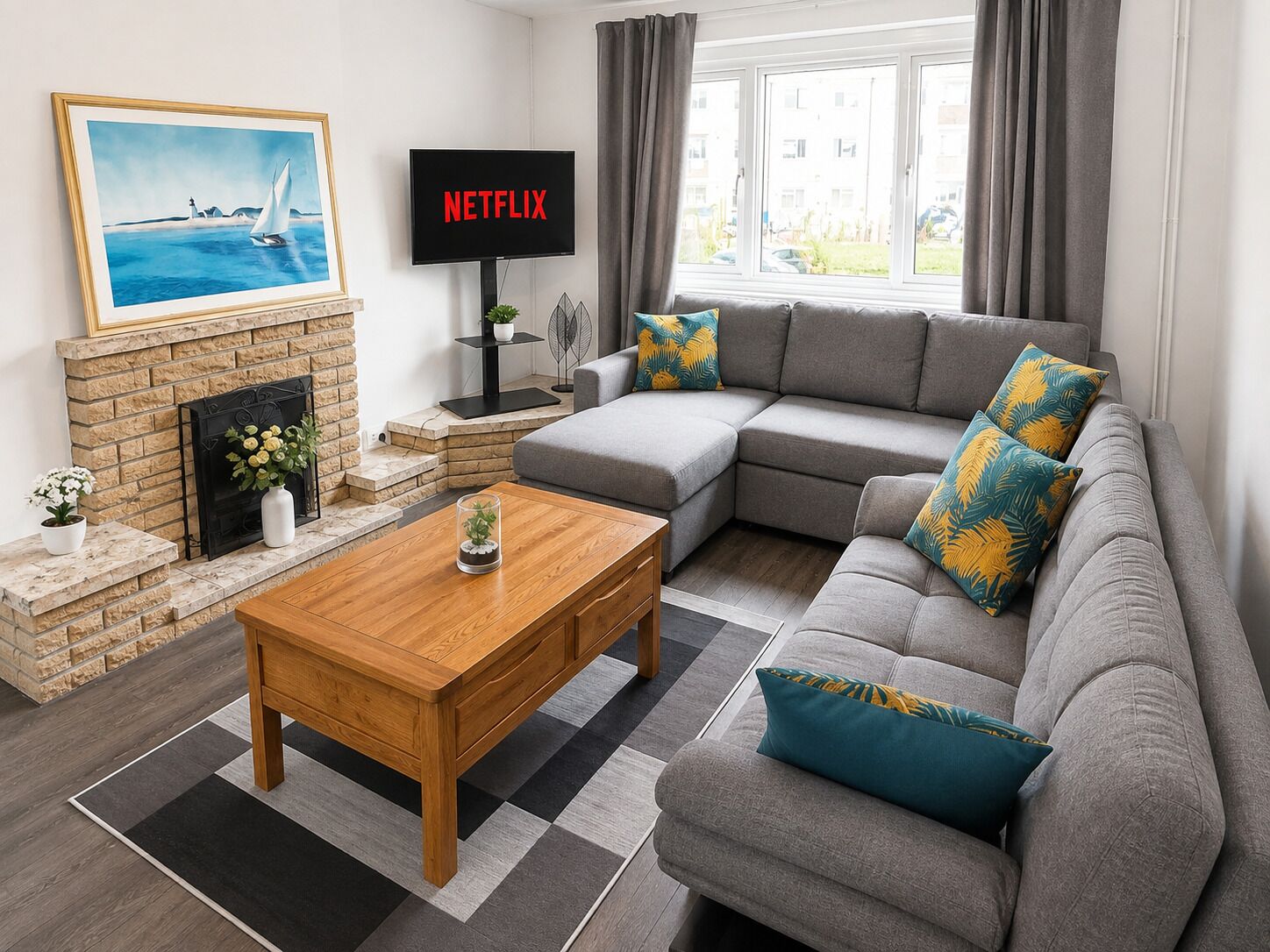 A living room with a fireplace, a sofa set, a coffee table, and a television displaying 'NETFLIX'.