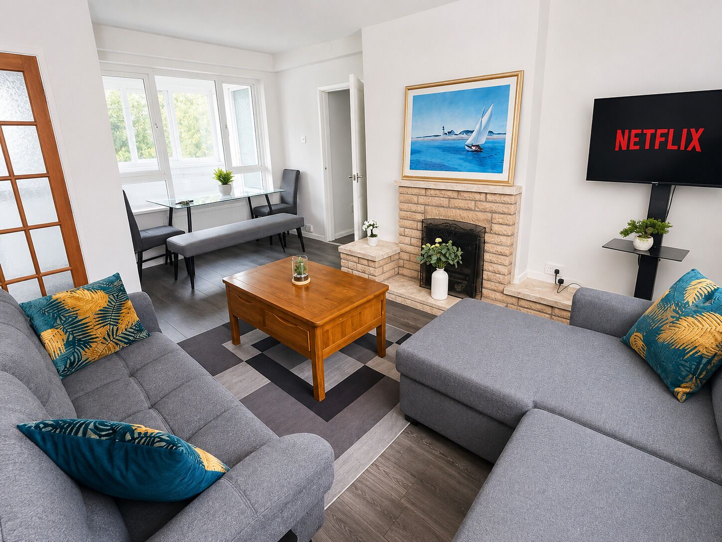 A modern living room with grey sofas, a wooden coffee table, and a fireplace.