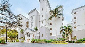 A multi-story hotel with a symmetrical facade, large windows, and a central entrance. - Luxurious condo with on-site pool, private extended balcony, & W/D (Naples)