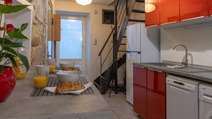 Cozinha com espaço para refeições, escada e máquina de lavar louça.