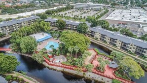 Un hôtel doté d’une piscine, entouré de verdure et bordé d’un plan d’eau.