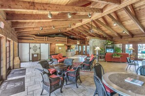 A spacious lobby with high ceilings, wicker furniture, a reception desk, and a stone wall. - Water view condo with WiFi, screened balcony, pool, tennis, & on-site dining (Naples)