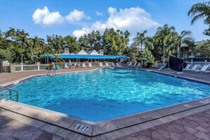 A rectangular pool with a 6 ft depth marker, surrounded by lounge chairs and palm trees. - Water view condo with WiFi, screened balcony, pool, tennis, & on-site dining (Naples)