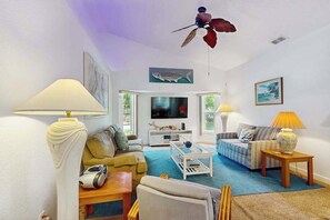 A living room with a sofa, armchairs, a coffee table, a TV, and a ceiling fan. - Relax, Recharge & Explore. Your Waterfront Getaway Awaits. (Punta Gorda)