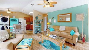 A living room with a sofa, coffee table, and a dining area with chairs and a table. - Pool, Game Room & Waterfront | 30+ Days (Port Charlotte)