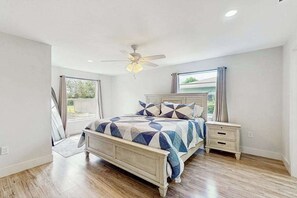 A bedroom with a bed, a nightstand, a ceiling fan, and a window. - Relax in Style home screened porch, WiFi, in-unit washer/dryer (Naples)