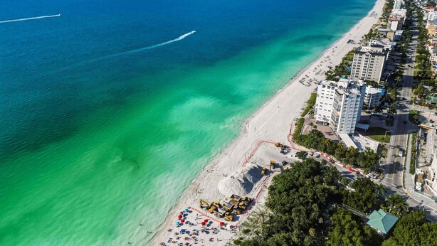 An aerial view of a coastal area with a beach, buildings, and a clear blue sea. - Contemporary and cozy home with heated pool, central location, close to beaches (Naples)