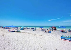 A beach with umbrellas and beach chairs. - Sunny Snowbird Retreat with a Pool, Furnished Lanai, & Prime Corner Lot (Port Charlotte)