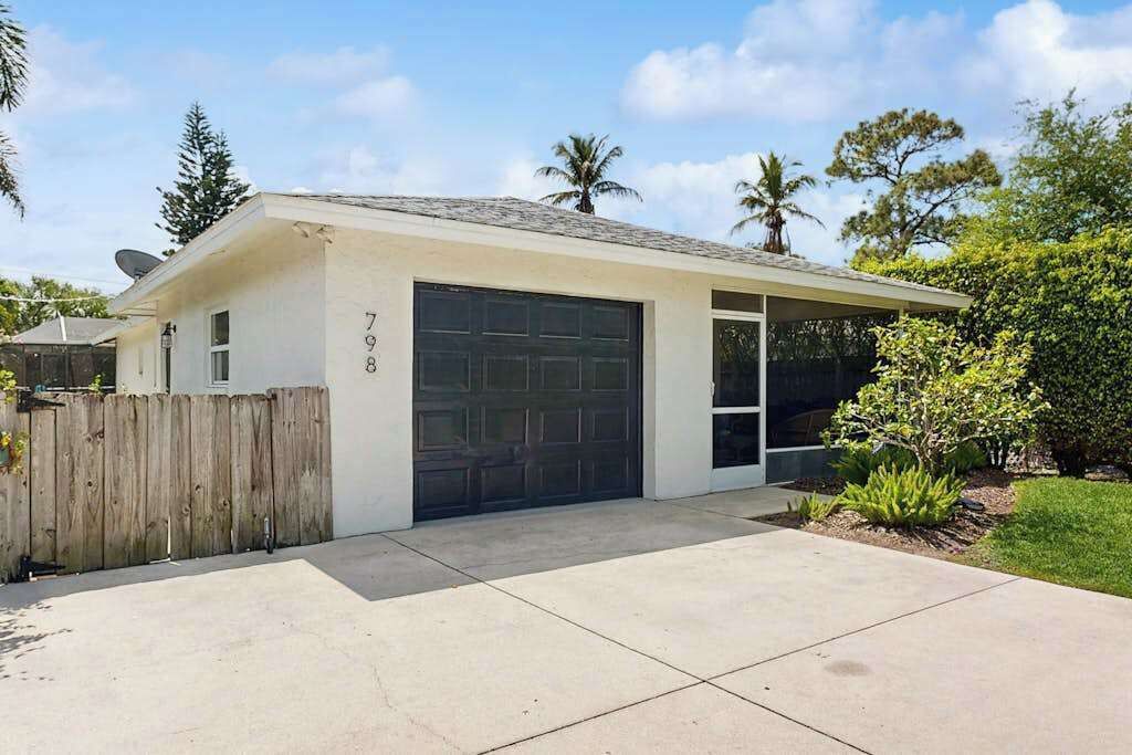 A single-story house with a garage, a covered porch, and a fenced yard.