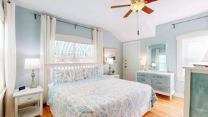 A bedroom with a bed, a nightstand, a dresser, a ceiling fan, and a window. - Dog-friendly duplex with outdoor living - walk to beach & downtown (Venice)