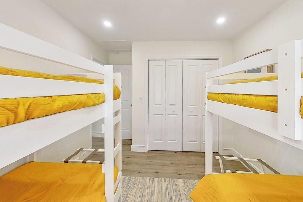 A room with bunk beds, a wardrobe, and a door.