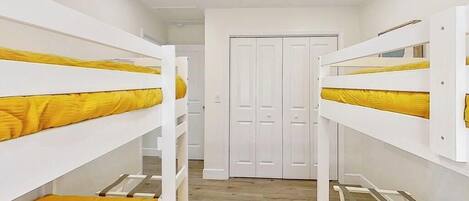 A room with bunk beds, a wardrobe, and a door.