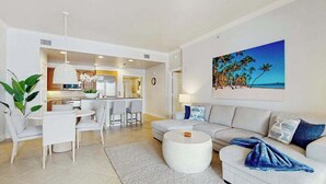 Uma sala de estar moderna com sofá, mesa de centro e área de jantar.