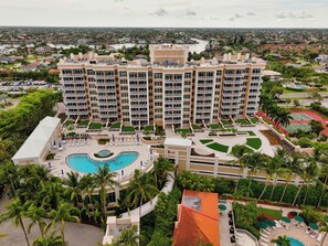 A multi-story hotel with a swimming pool, landscaped gardens, and a view of the surrounding residential area. - Renovated Gulf-front condo with a pool, a hot tub, & central AC (Marco Island)