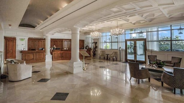Un hall espacioso con techos altos, ventanas amplias y muebles modernos.
