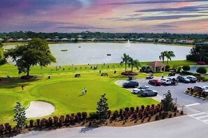 A golf course with a lake, a pavilion, and a parking area. - Resort community home with bikes, screened porch, on-site golf, & AC (Naples)