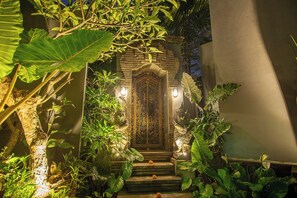 A traditional entrance with a stone archway, steps leading up to a door, and surrounding lush greenery. - private 4-bedroom villa with Infinity pool in peaceful Ubud (ubud)