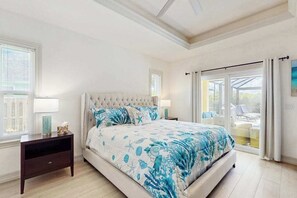 Ein Schlafzimmer mit einem großen Bett, einem Nachttisch, einem Fenster und Blick ins Freie.
