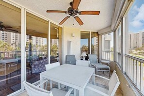 Ein Balkon mit Deckenventilator, Tisch und Stühlen.