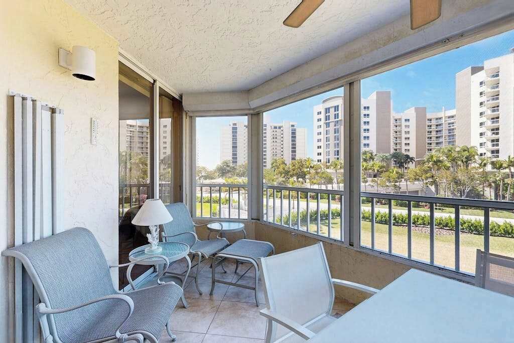 Uma varanda com assentos, uma mesa e vista para prédios altos.