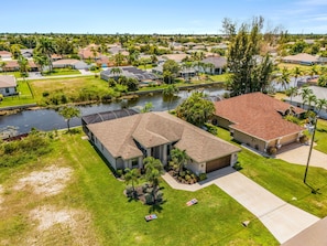 Un barrio residencial con casas, un río y un césped bien cuidado.