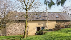 A stone building with a sloped roof, a small porch, and a grassy yard. - Pylemoor Cottage (Tiverton)