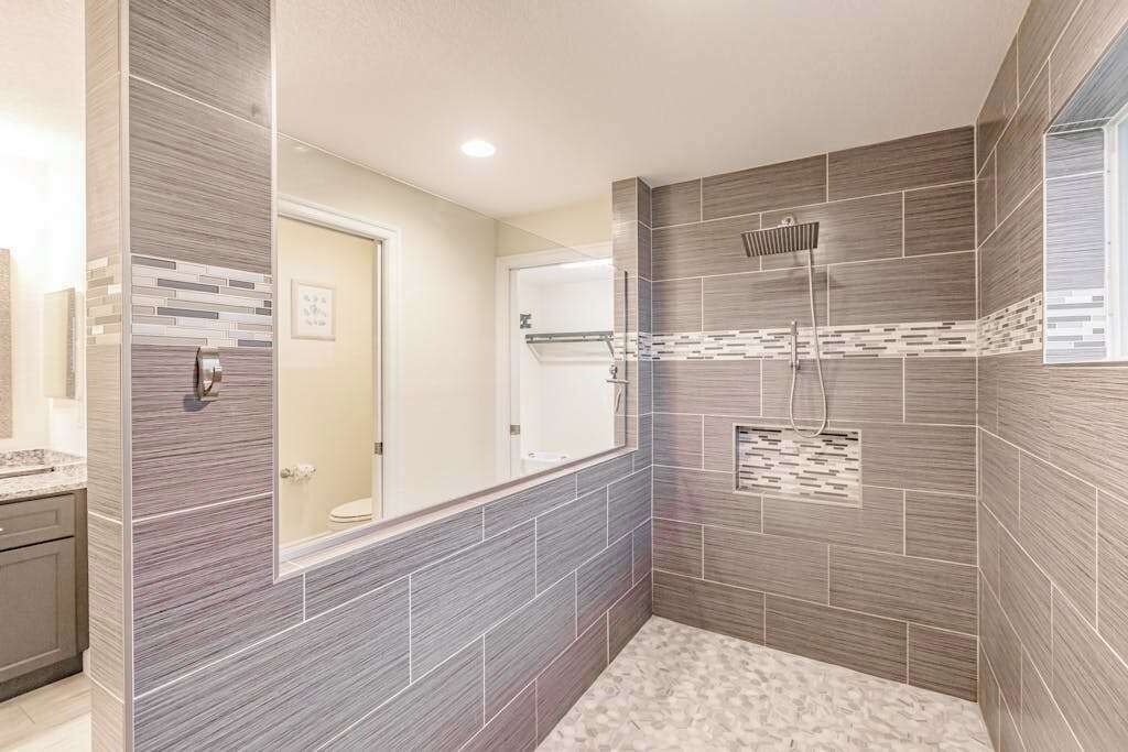 Een moderne badkamer met een douche, betegelde wanden en een zichtbaar toilet.