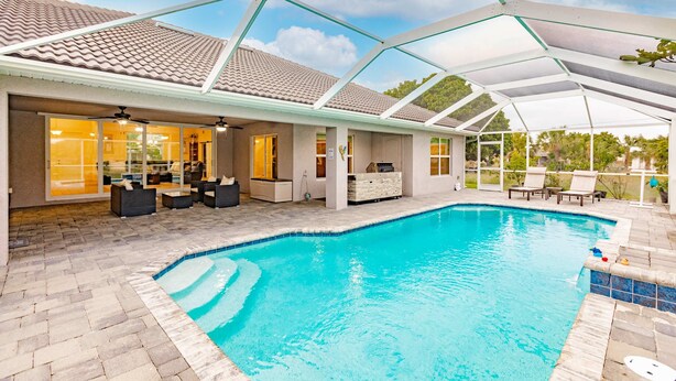 Una piscina coperta con una zona solarium, una cucina e un soggiorno.