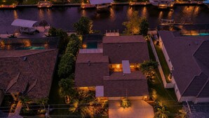 Luchtbeeld van een woongebied met huizen, een zwembad en een steiger.
