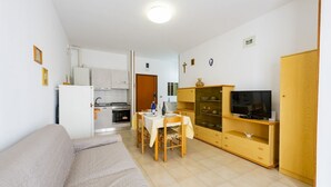A compact living space with a kitchenette, a dining area, a sofa, and a TV. - GuestHost - Alba Cozy Flat near the Sea W/Parking (Alba Adriatica)
