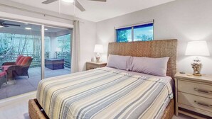 A bedroom with a bed, a nightstand, a lamp, a ceiling fan, and a view of the outdoors. - Dog-friendly duplex with a patio, deck, washers, dryers, & central AC (Naples)